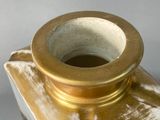 a gold vase that is sitting on a table