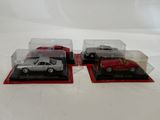 three model cars are in a display case on a white surface