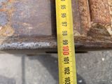 a measuring tape that is on the side of a rusted pipe
