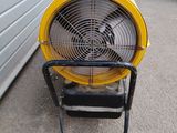 a yellow fan sitting on the side of a building
