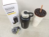 thermos flask is next to a cup with a straw in it