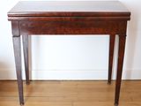 a small table with a wooden top on a hard wood floor