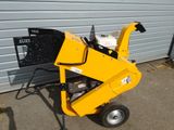 an image of a small wood chipper parked in front of a garage