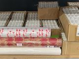 many rolls of wrapping paper on a shelf in a warehouse