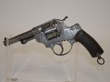 an old gun on a clear stand on a white surface