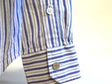 striped blue and white shirt hanging on a hanger in a room