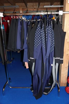 beaucoup de vêtements suspendus à une étagère dans une pièce