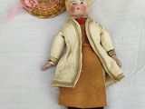 a doll that is laying on the ground next to a basket