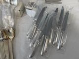 a lot of knives and spoons on the table
