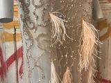 a mannequin in a dress with feathers on it