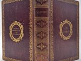 un vieux livre relié en cuir, orné de dorures et d'un cadre illustré sur la couverture
