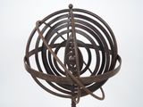 une sculpture métallique représentant un objet tournant posé sur un socle