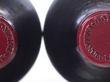 two bottles of wine sitting next to each other on a table