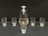 quatre verres et une carafe posés sur une table