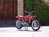 a red dirt bike parked in front of a stone building
