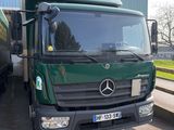 un grand camion vert garé devant un immeuble