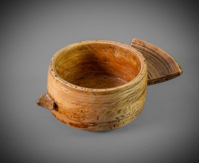 an image of a wooden bowl with a lid on a gray background