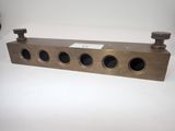 a brass plate with four holes on the top of it