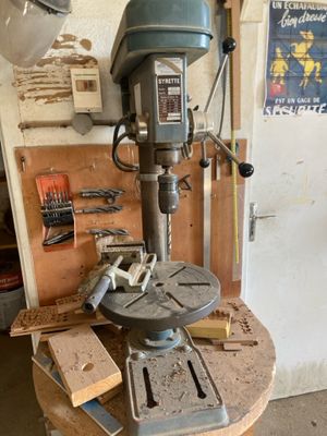 une perceuse posée sur une table dans un garage