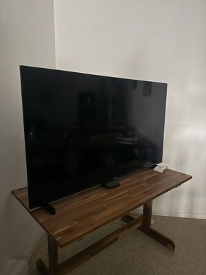 une photo d'un téléviseur à écran plat posé sur un meuble en bois