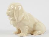 a figurine of a dog sitting on a white surface