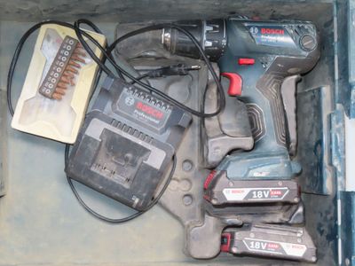 une boîte contenant une perceuse et d'autres outils
