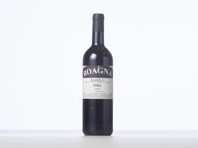a bottle of red wine sitting on top of a white table