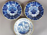 trois assiettes bleues et blanches à motifs posées sur une table