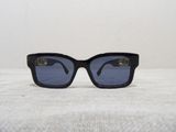 black sunglasses with blue lenses sitting on top of a white surface