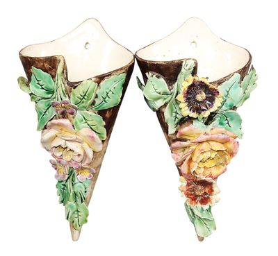 une paire d'appliques murales en céramique ornées de fleurs et de feuilles