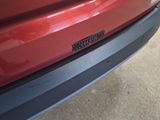a close up of a red car with a sticker on it ' s bumper