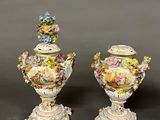 two vases with flowers on them sitting next to each other