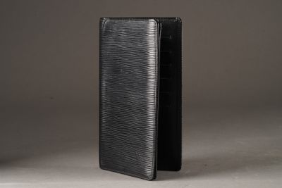 a black wallet sitting on top of a table next to a white wall