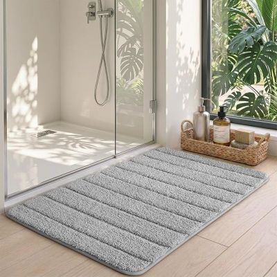 un tapis de bain posé par terre devant la douche