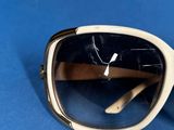 pair of sunglasses on a blue surface with a cigar in the background