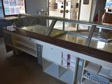 a counter with a glass display case in the middle of the room