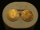 deux pièces d'or posées sur un socle blanc