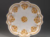 une assiette orange et blanche ornée d'un motif floral