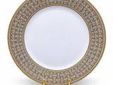 a gold and white plate with a greek motif on it