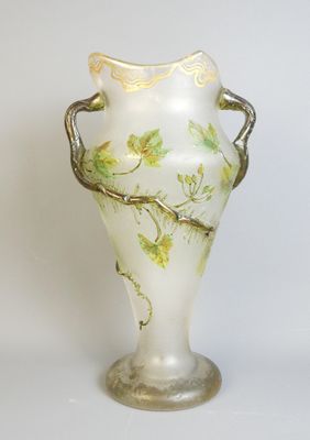un vase blanc orné d'un motif vert et doré