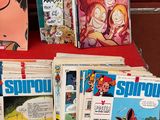 plein de bandes dessinées posées sur une table rouge