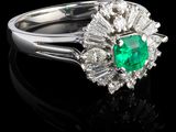 une bague en émeraude et diamant sur une surface noire