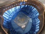 a hat with a blue ribbon around it on a table