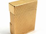 an antique gold cigarette case on a white surface with a white background