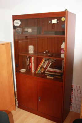 a wooden bookcase with many books on it in a room