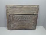 an old wooden box sitting on a white surface with a rope