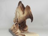 a small figurine of a fish on a book