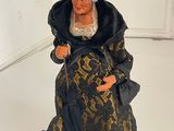 a figurine of a woman dressed in a black and gold dress