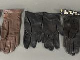 four pairs of leather gloves lined up on top of a table