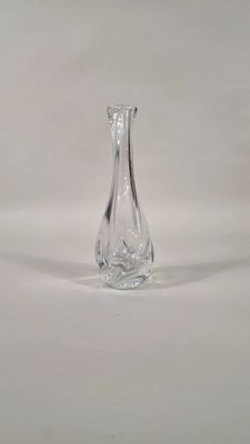 un vase en verre transparent posé sur une surface blanche